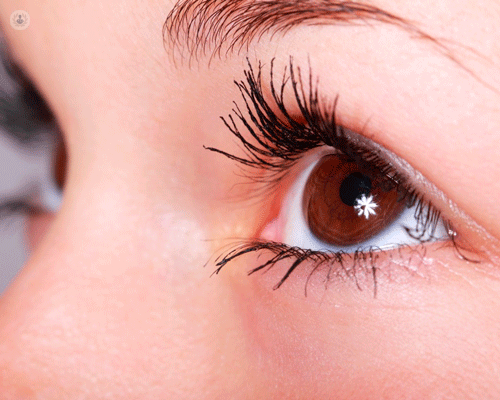 Persona che indossa EyeLente a contatto per trattare linfiammazione oculare diffusa, con una linea di cosmetici per occhi che donano al volto un aspetto sano e luminoso