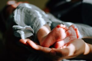 Un bambino con distrofia muscolare congenita si stringe un dito con la mano, mostrando la fragilità della parte del corpo colpita dalla malattia