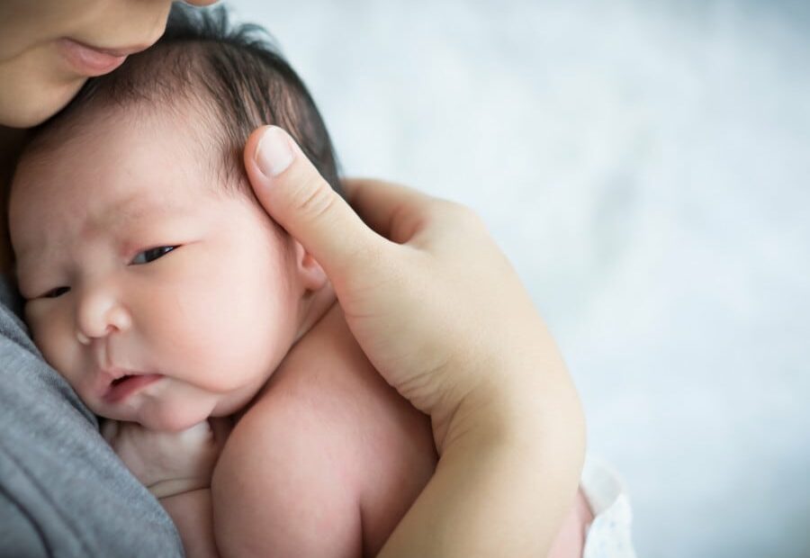 Un ritratto di un neonato, che soffre di un deficit ormonale tiroideo, ritrae la testa e il viso di una piccola persona in una fotografia di grande impatto emotivo
